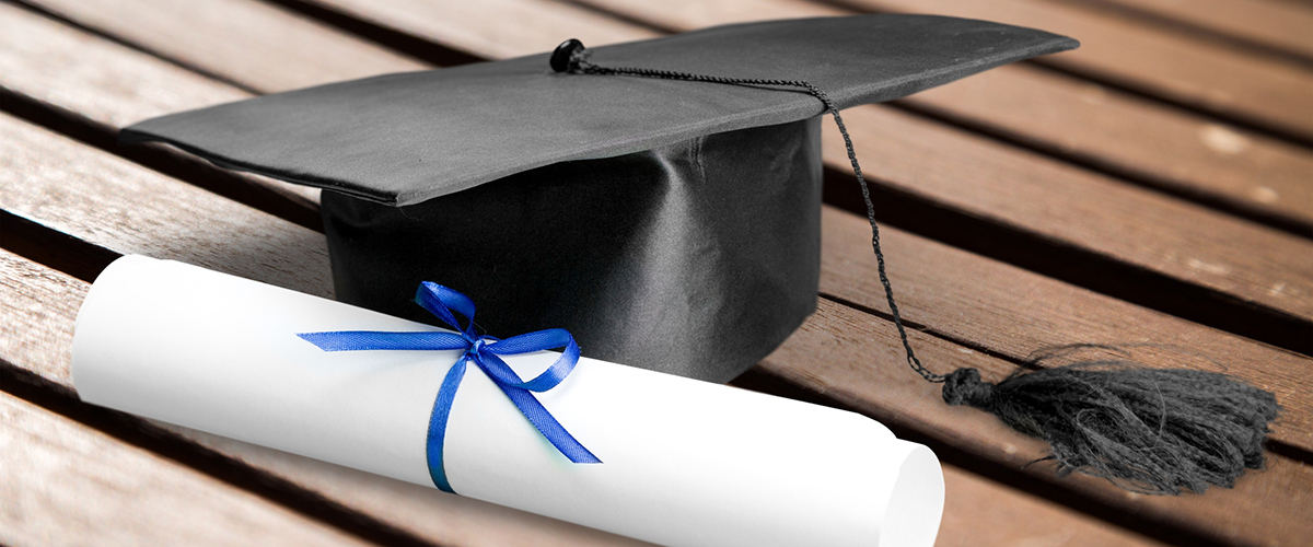 Photo of a diploma and graduation hat