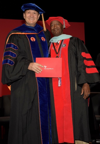 Nelson Simpson, on the right, poses for a photo during graduation.