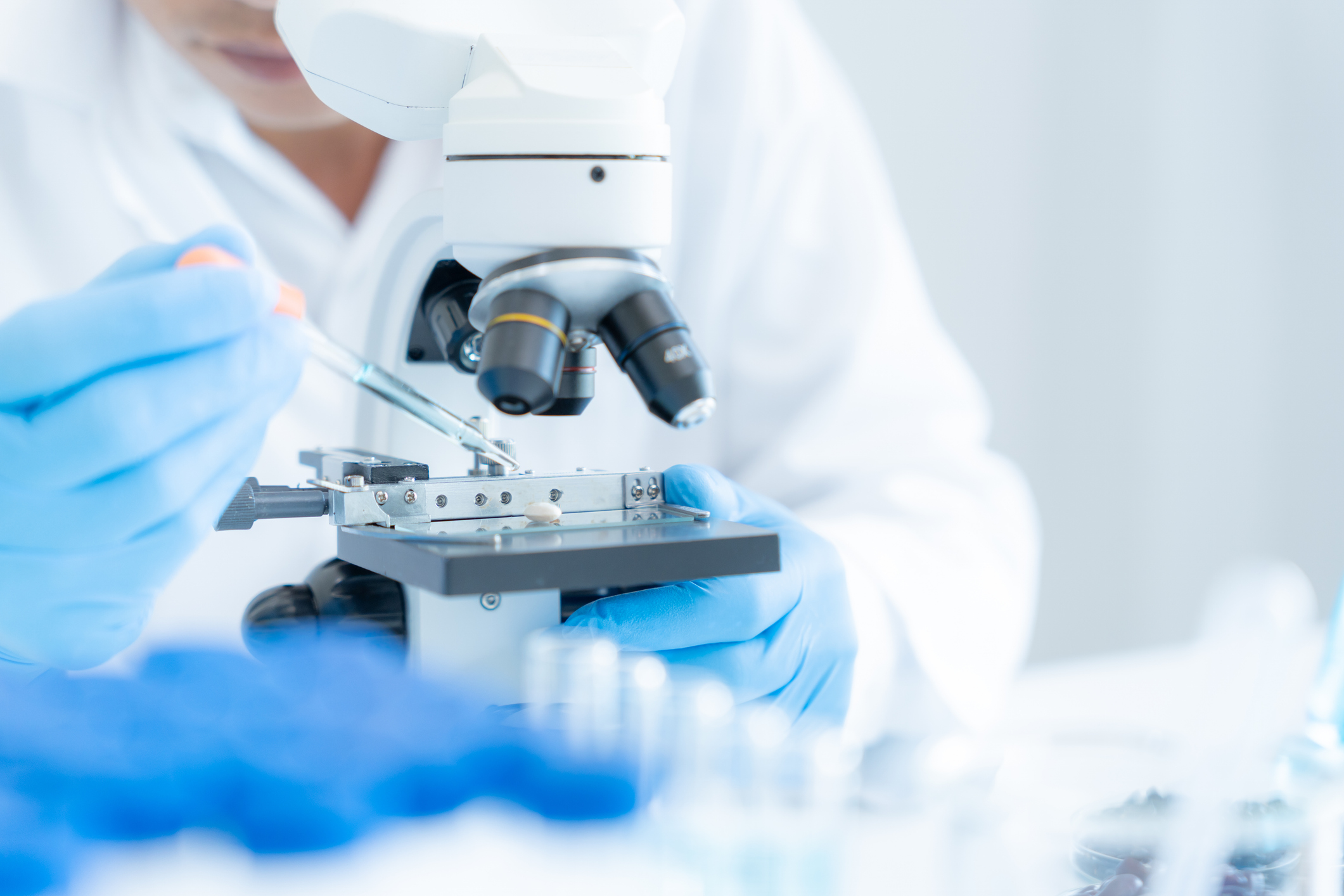 Medical professional examining a specimen under a microscope